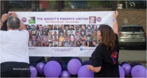 A group of people are holding up a banner for the aodh's parent's united.