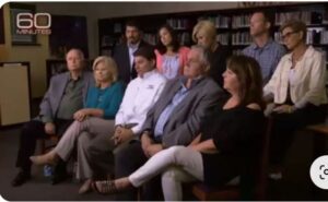 A group of people sitting in front of a bookcase.