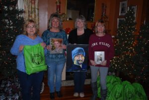 Four women standing in front of a christmas tree.