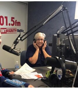 Two people sitting at a microphone in front of a microphone.