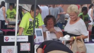 A group of people standing under a tent at an outdoor event.