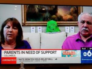 Two people sitting on a tv screen with parents in need of support.