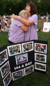 Two ladies hugging each other at an open field