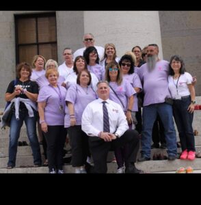 A group of people in purple shirts posing for a photo.